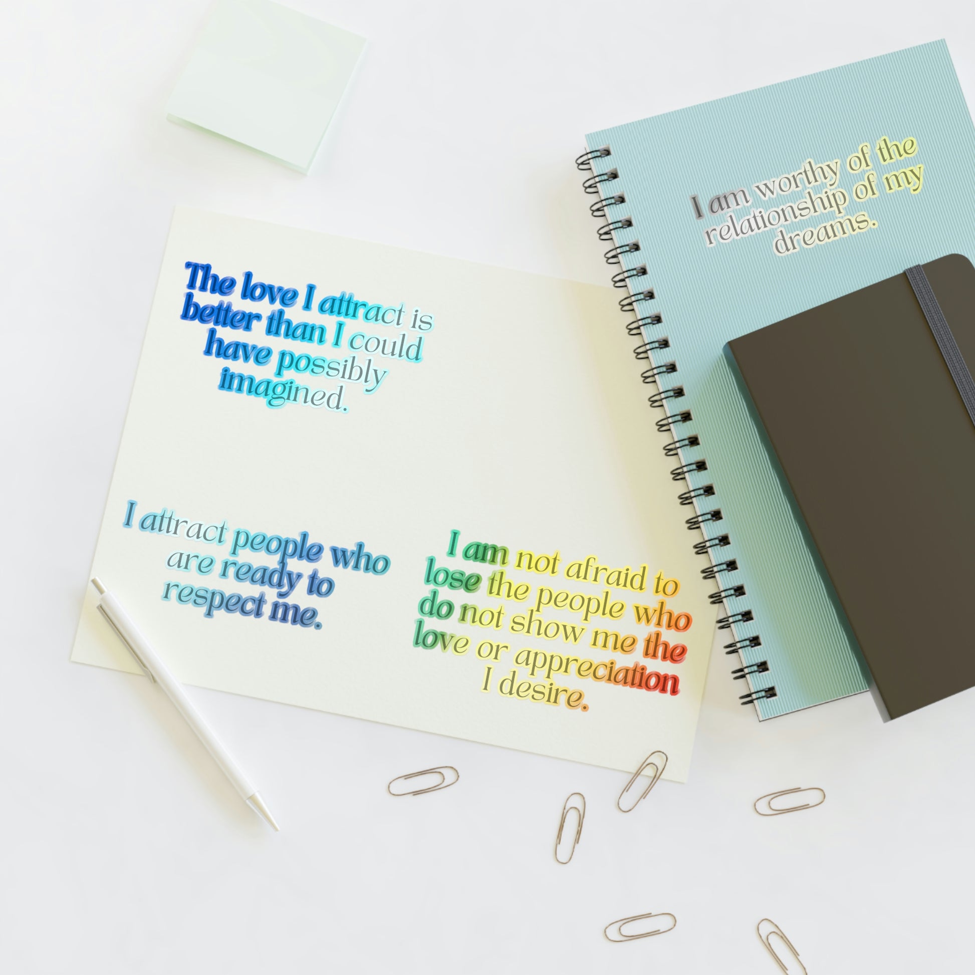 Holographic shiny stickers with love affirmations on a journal.